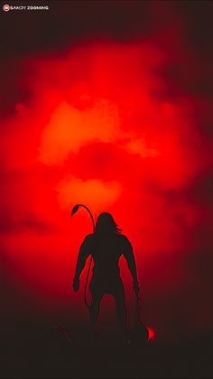 the silhouette of a man in front of a red sky