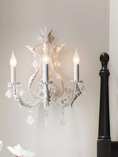 a chandelier hanging from the side of a wall next to a candle holder