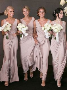 the bridesmaids are all dressed in gray dresses and holding bouquets with white flowers