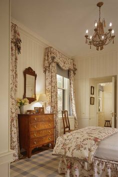 a bed sitting in a bedroom next to a dresser with a mirror on top of it