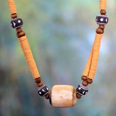 a wooden beaded necklace with beads and wood beads on it's end is shown in front of a blurry background