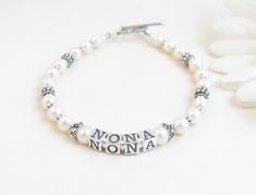 "Beaded Name Bracelet: Created with real freshwater pearls, 4.5mm sterling silver alphabet blocks and gorgeous sterling silver accent beads. The name on the bracelet can be hers, her child or grandchild's name, or something like Nana, Mimi, Grandma, Mommy, etc. The base price includes 6 letters. Each additional letter is $2. I can usually fit two names on the bracelet if desired (contact me if you need more than 12 letters) Note: The bracelet on the model is all sterling silver (no pearls) and i White Hypoallergenic Name Bracelet For Anniversary, Hypoallergenic White Name Bracelet For Anniversary, White Pearl Bracelet For Mother's Day Anniversary, Personalized White Bracelet For Anniversary, White Pearl Bracelet For Anniversary And Mother's Day, White Pearl Bracelet For Anniversary On Mother's Day, Elegant White Name Bracelets, Elegant Hypoallergenic Name Bracelet With Round Beads, Elegant Handmade Name Bracelet With Round Beads