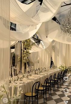 a banquet hall with tables and chairs covered in white drapes