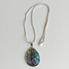 Abalone / paua shell necklace on stainless steel snake chain (to prevent tarnishing).    Presented in velvet -lined gift box. Length: approximately 42cms Pendant length: 42mms Pendant width: 32mms Check out my full jewellery range at: www.tanyajaynechains@etsy.com Silver Abalone Shell Pendant Necklace, Silver Shell Necklace With Pearl Pendant As Gift, Silver Shell Necklace With Round Pendant For Gift, Silver Mother Of Pearl Shell Necklace As Gift, Shell Necklace With Large Pendant, Silver Abalone Shell Necklace Gift, Gift Shell Necklace With Large Pendant, Silver Shell Pendant Necklace For Gift, Silver Pendant Shell Necklace Gift