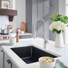 a bowl of food sitting on top of a kitchen counter next to a sink and stove