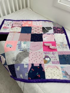 a bed with a quilted blanket on top of it