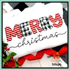 a merry christmas pillow with the word merry written in black and white on it, next to a red ribbon