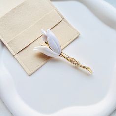 Indulge in pure sophistication with our Elegant White Tulip Brooch. Crafted with exquisite detail, this brooch adds a touch of luxury to any outfit.
Its delicate white tulip design exudes elegance and grace, making it the perfect accessory for any special occasion.
Elevate your style and make a statement with this exclusive piece. Luxury White Pins For Gifts, Luxury White Elegant Brooches, Luxury White Flower Brooches, Tulip Design, White Tulips, Elevate Your Style, Mother's Day Gift, Tulips, Mother's Day Gifts