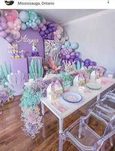 a table set up with balloons, cake and decorations for a mermaid themed birthday party