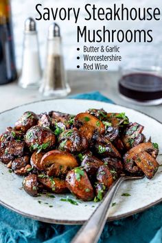 savory steakhouse mushrooms on a white plate with a glass of wine in the background