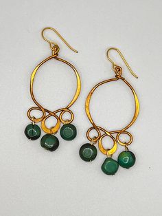 Vintage old brass earring with a beautiful blue green turquoise coin bead dangles. Bohemian Bronze Earrings With Round Beads, Bohemian Gold Jade Earrings, Green Wire Wrapped Metal Earrings, Handmade Green Metal Chandelier Earrings, Bohemian Round Jade Earrings, Bohemian Gold Jade Jewelry, Green Bohemian Metal Chandelier Earrings, Green Metal Bohemian Chandelier Earrings, Green Bohemian Chandelier Earrings