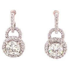 Beautiful Diamond halo drop dangling earrings in 18k white gold. These gorgeous earrings feature two round brilliant cut diamonds at the center, each measuring approximately 5.80 mm x 5.80 mm x 3.45 mm with the approximate carat weight of 0.70 ct. each. The center diamonds are H in color and SI1 - SI2 in clarity and totaling approximately 1.40 carats. The center diamonds are set in four prongs and surrounded by pave' set diamond halos. The halos are attached to an horse shoe design also pave' se Diamond Settings, Gorgeous Earrings, Round Brilliant Cut Diamond, Earring Backs, Brilliant Cut Diamond, Halo Diamond, Round Diamonds, Jewelry Earrings Dangle, Diamond Earrings