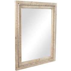 a white framed mirror sitting on top of a wall