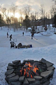 people are skiing around a fire pit in the snow