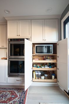 a kitchen with white cabinets and open shelves