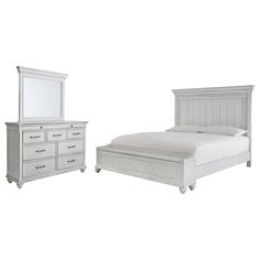 a white bed sitting next to a dresser and mirror