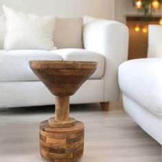 a white couch sitting next to a wooden table on top of a hard wood floor