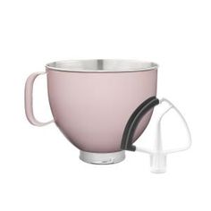 a pink mixer sitting on top of a white counter next to a metal bowl with a black handle