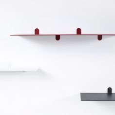 two red shelves are on the wall next to each other