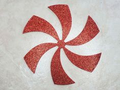 a red glittered candy cane on a white surface