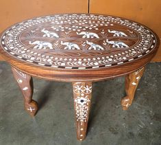 a wooden table with elephants painted on it