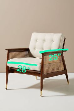 a white chair with green trim and numbers on the arm rests against a beige wall