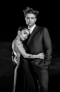 a man and woman are posing for a black and white photo with their arms around each other