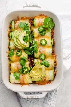 a casserole dish filled with meat, cheese and veggies covered in sauce