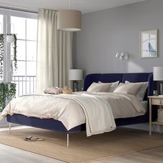 a bedroom with a blue bed and white walls