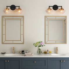 two sinks and mirrors in a bathroom with blue cabinets