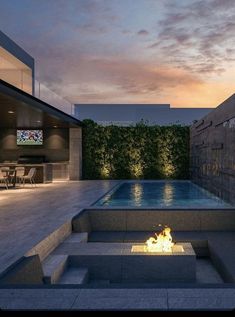 a fire pit in the middle of a patio with a tv on it's wall