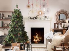 a living room filled with furniture and a fire place next to a christmas tree in front of a fireplace