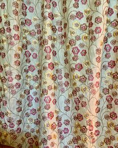 a curtain with flowers on it in front of a window