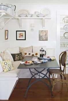 a table with plates and cups on it in front of a white wall filled with dishes