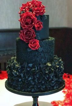 a three tiered black and red cake with roses on top