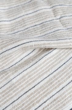 a close up of a blanket on top of a bed with blue and white stripes