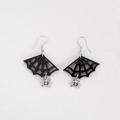 "These cute spiderweb earrings are the perfect gift for any girl who loves spiders. 💀 DESCRIPTION: This pair of drop earrings features small 3-D cast spider charms that hang from gloss black spiderwebs. They were attached to hypoallergenic stainless steel ear wires. 💀 SIZE & MATERIALS: The spiderwebs were laser cut from acrylic. The spider charms were made from sterling silver and measure approximately 3/8\". The ear wires are made from hypoallergenic stainless steel. Overall, the earrings Spooky Black Jewelry Gift, Spooky Adjustable Black Jewelry, Adjustable Black Spooky Jewelry, Black Novelty Jewelry For Gifts, Nickel-free Black Spooky Earrings, Spooky Black Nickel-free Jewelry, Nickel Free Themed Black Jewelry, Black Novelty Drop Earrings, Themed Black Dangle Earrings