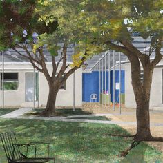 an empty park bench sits in front of a building with trees on the side walk