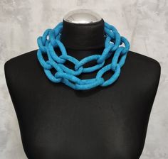 a black mannequin with a blue necklace on it