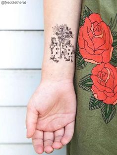 a person with a tattoo on their arm holding onto a red rose and playing cards