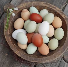 a bowl filled with eggs sitting on top of a wooden table