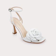 Elevate your style with the Aurora II, a stunning high heel from Dee Ocleppo crafted from premium leather. Featuring a bold, oversized rose embellishment on the toe, this shoe is designed to make a statement. The elegant ankle strap ensures a secure fit, while the uniquely shaped heel adds a modern touch to this classic design. Perfect for special occasions or a night out, the Aurora II combines sophistication and standout style in one exquisite package. - Heel Height: 3 inches - Fit: True to si The Aurora, Floral Applique, Leather Heels, White Leather, Leather Sandals, High Heel, Classic Design, Aurora, Ankle Strap