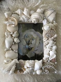 there is a photo frame with shells and pearls on the bottom, along with other seashells