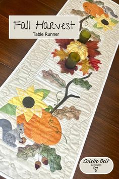 a table runner with fall leaves and flowers on it