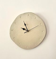 a white clock with black hands on a wall