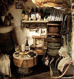 a room filled with lots of clutter next to a wooden table and wine barrel