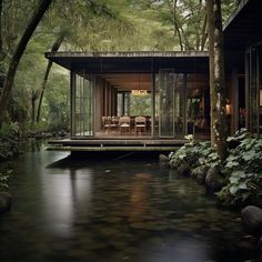 a house in the woods is surrounded by water and trees, with chairs on the deck