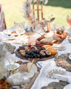 the table is set with plates and bowls of food, including fruit on skewers