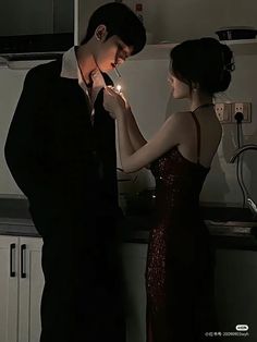 a man and woman standing next to each other in front of a stove top oven