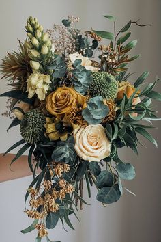 An emerald green and gold bridal bouquet with roses and eucalyptus. Green And Gold Bouquet, Green Bouquets, Gold Bouquet, Emerald Green And Gold, Boho Wedding Bouquet, Faux Flower Arrangements